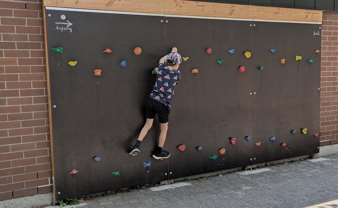 Kind an der vom Förderverein finanzierten Kletterwand auf dem Schulhof